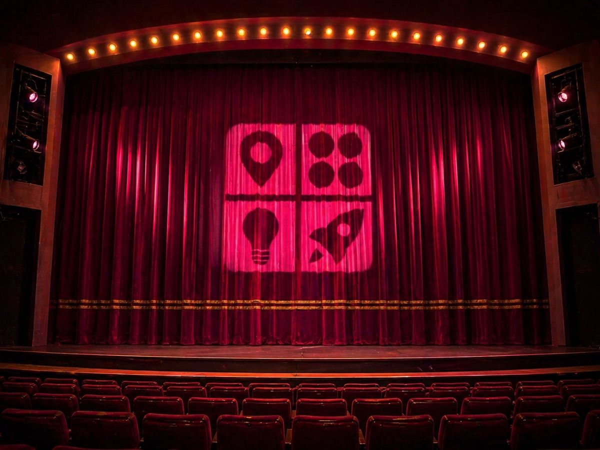 Light projected on red theater curtains shows icons of a location pin, bubbles, a lightbulb, and a rocket.