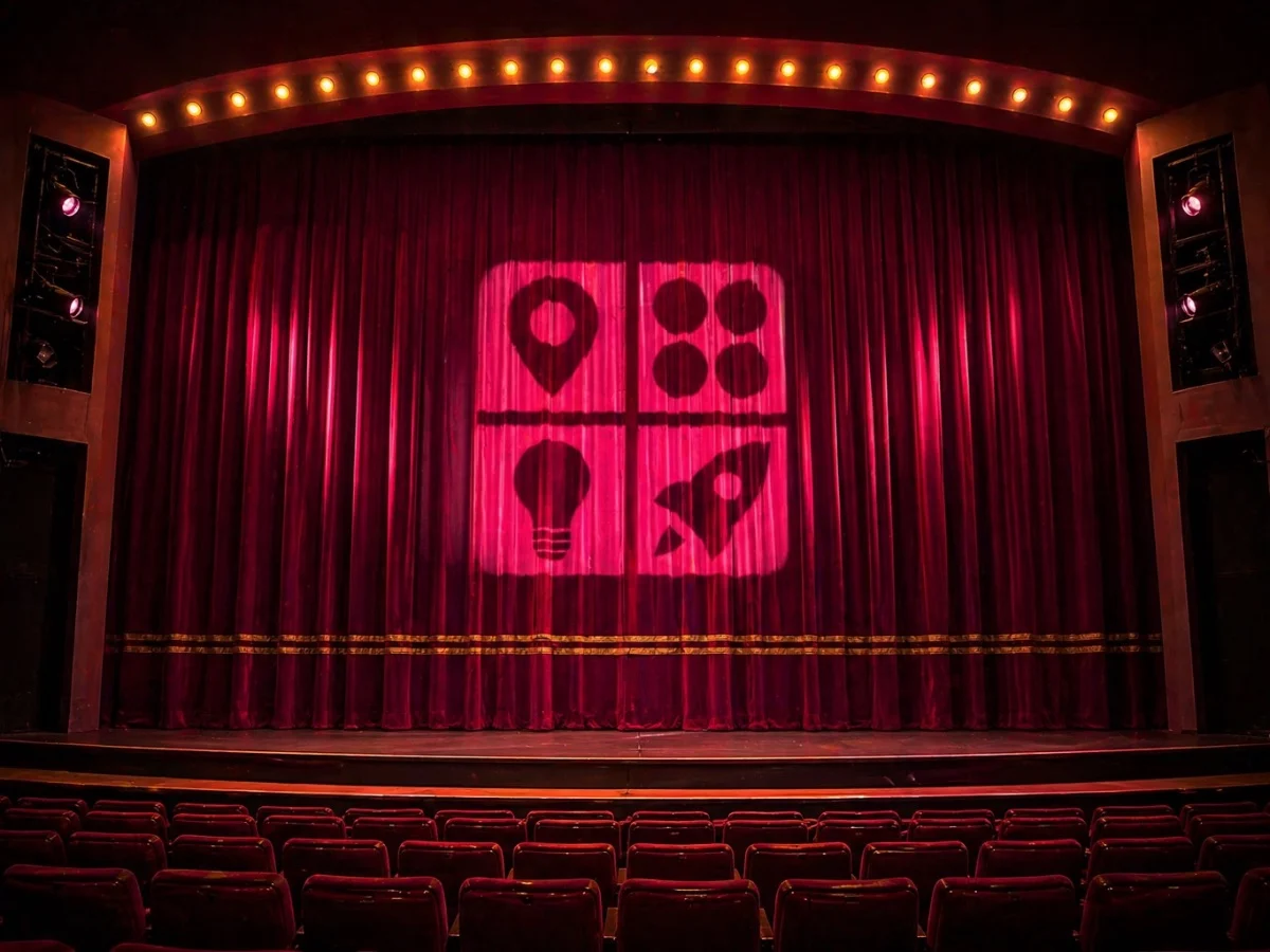 Light projected on red theater curtains shows icons of a location pin, bubbles, a lightbulb, and a rocket.